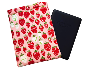 Kindle sleeve with snap to protect Kindle e-readers made with a pink back ground with red and white strawberries.